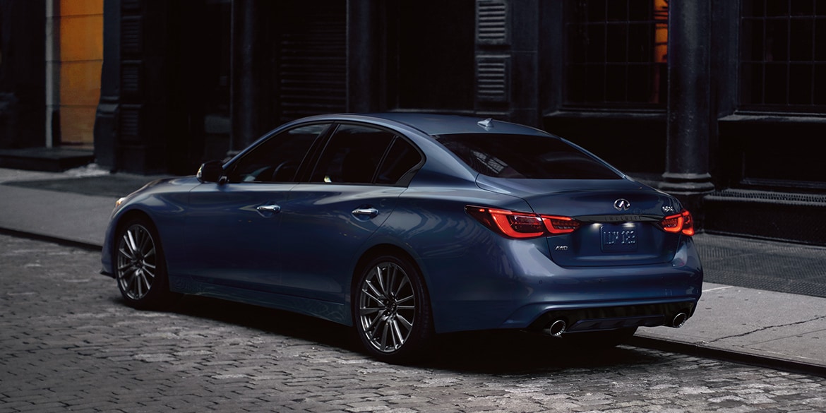 Rear profile view of 2024 INFINITI Q50 highlighting rear lights and performance-inspired exterior design